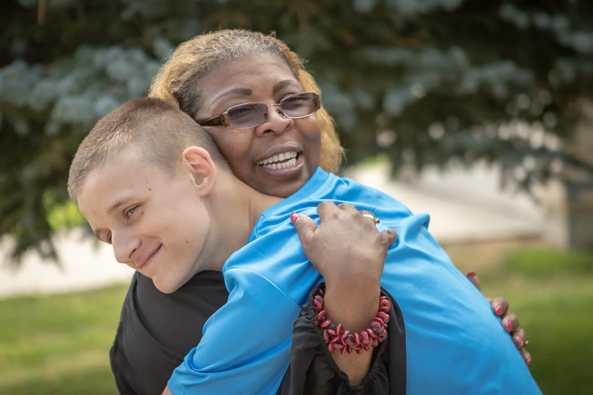 A volunteer provides heartfelt support by hugging a young member of a foster family.