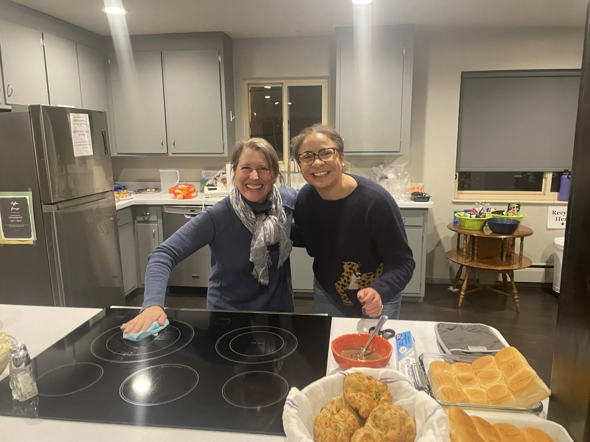 Two volunteers in a kitchen preparing a meal in support of foster families.